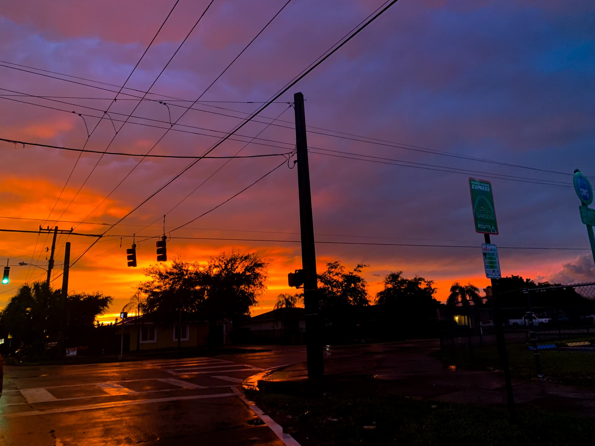 Violet and orange sunset over a wet intersection after rain